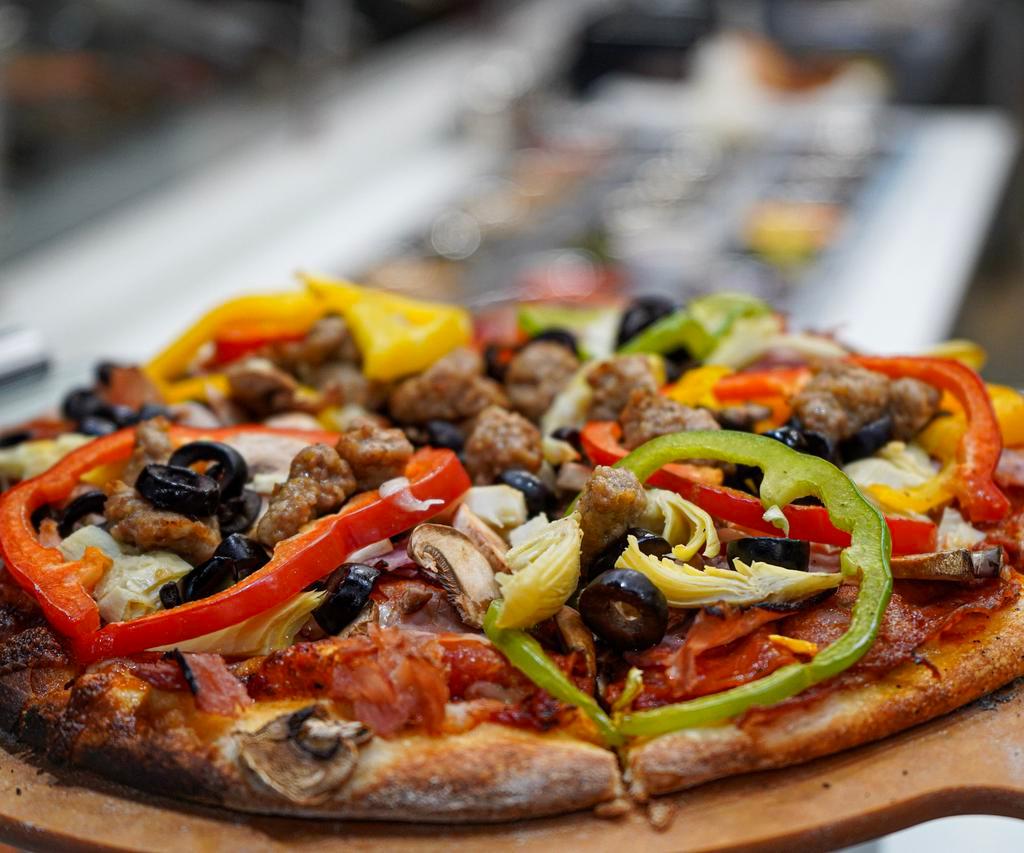 Combination Pizza · Red pizza sauce, mozzarella, linguica, bacon, pepperoni, sausage, peppers, onions, mushrooms, olives and artichoke hearts.