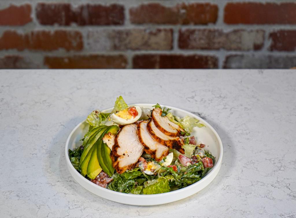 Cobb Salad · Baby greens with fresh-cut romaine, roasted chicken, avocado, fresh tomato, hard-boiled egg, bacon bits, blue cheese and chunky blue cheese dressing.