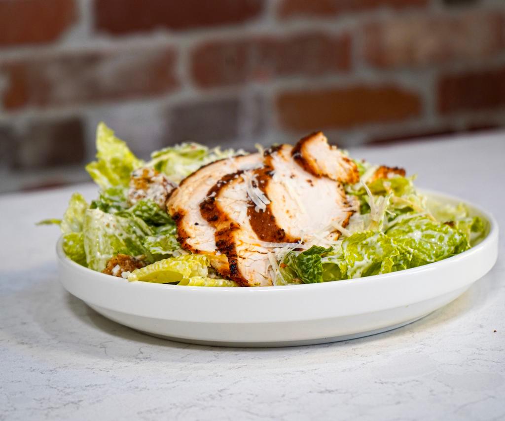 Roasted Chicken Caesar Salad · Fresh cut romaine, roasted chicken, sourdough croutons, Parmesan cheese, and zesty Caesar dressing.