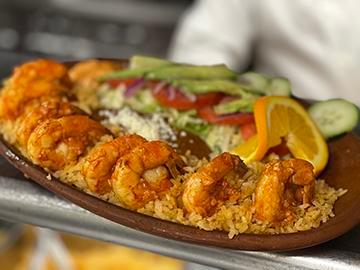 Camarones al Ajillo · Shrimp sauteed with garlic. Served with a house salad, Mexican rice, refried beans and garlic mayo.