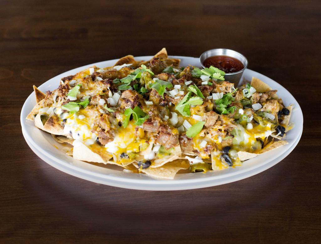 Carnitas Nachos · Freshly fried tortilla chips covered in carnitas, homemade black beans, jalapenos, avocado verde, sour cream, Jack and cheddar cheese and topped with onions and cilantro. Served with a side of salsa.