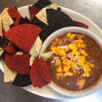 Bowl of Chili · Homemade chili with chopped onion, sour cream and tortilla chips.