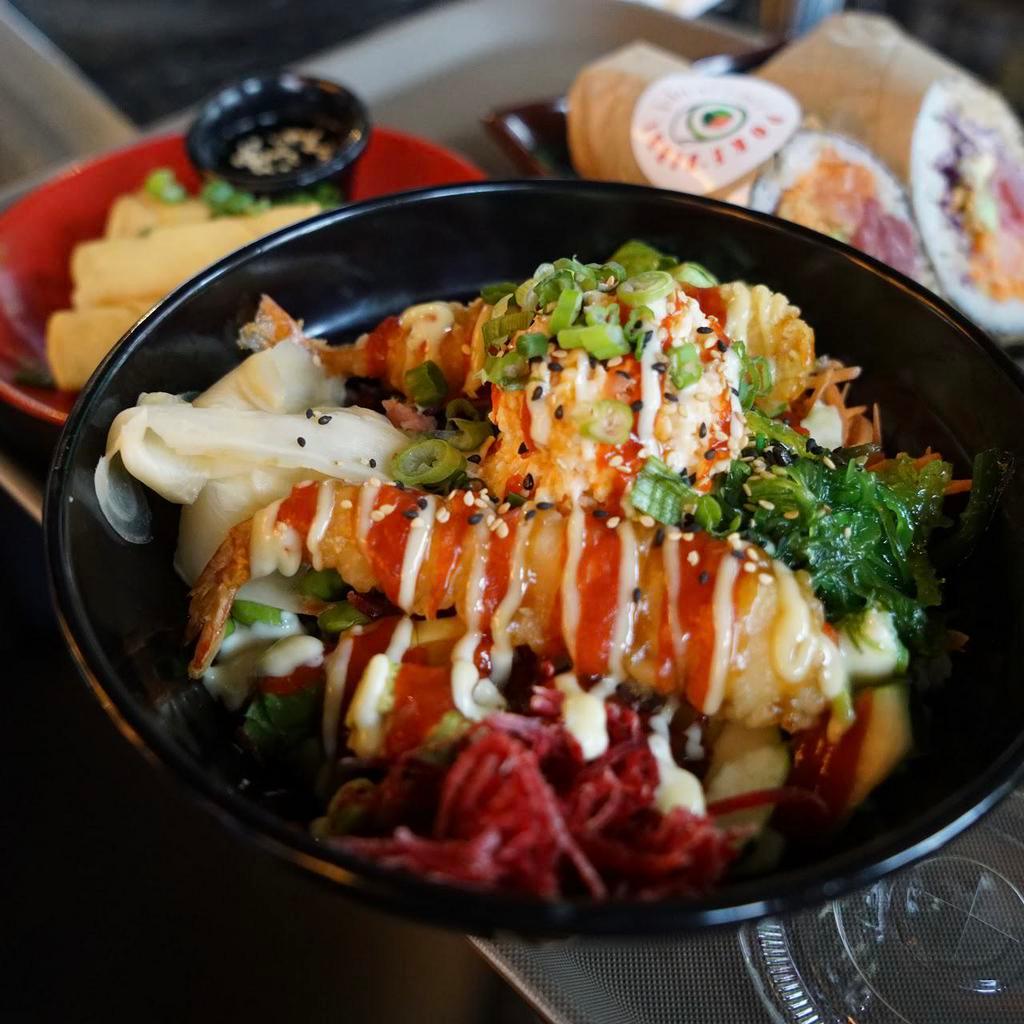Dynamite Spicy Tuna Bowl · Rice topped with sesame seeds, lettuce, edamame, cucumber, avocado, carrots, cabbage, beets, spicy tuna, tempura shrimp, eel sauce, spicy Korean sauce, jalapenos, and pickled ginger