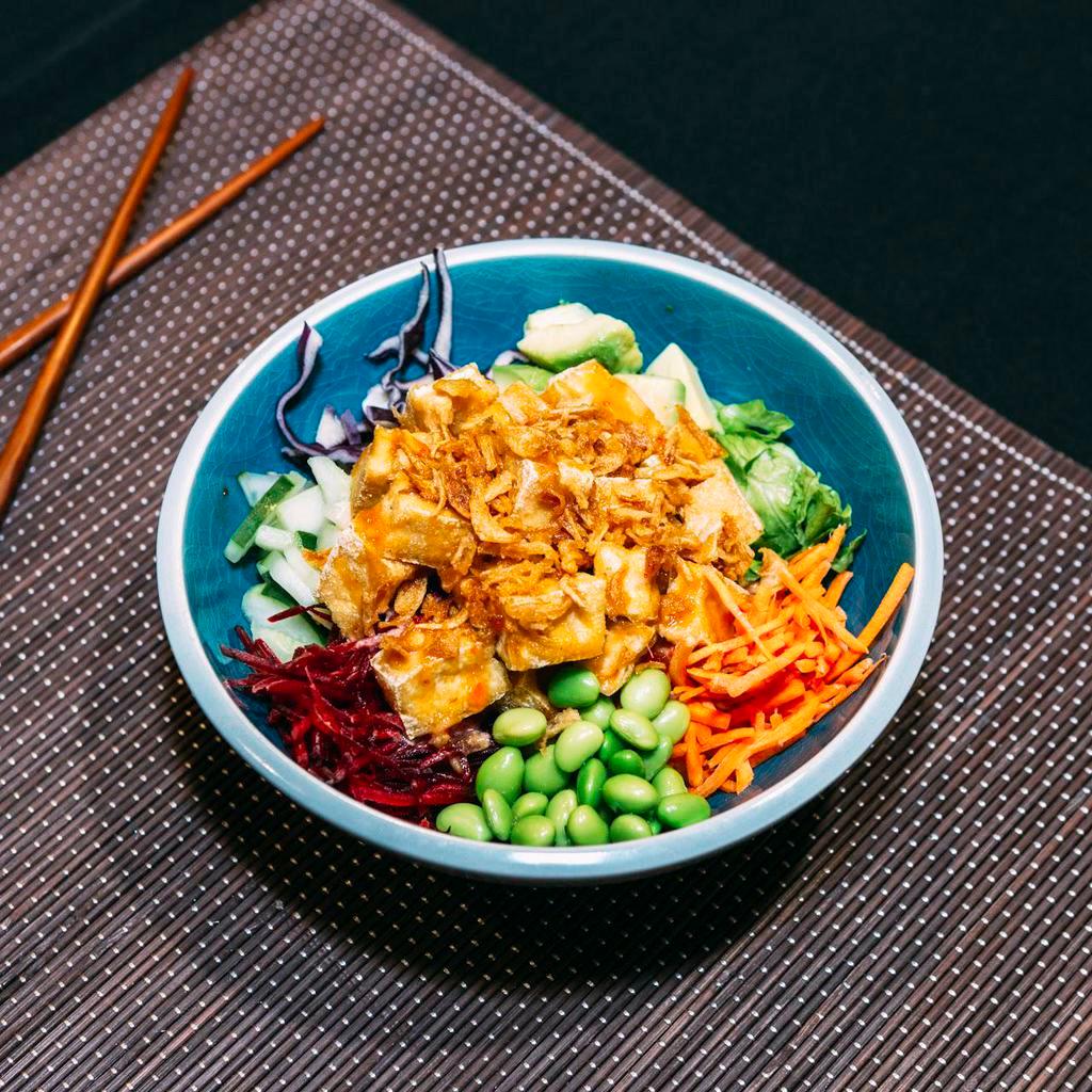 Soy-Mate Tofu Bowl · Rice topped with sesame seeds, lettuce, edamame, cucumber, avocado, carrots, cabbage, beets, spring mix, crispy tofu, ginger miso dressing, sweet chili peanut sauce, seaweed salad, and pickled ginger