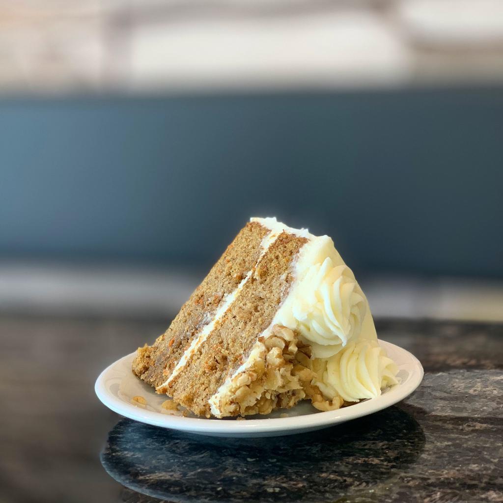 Carrot Cake · a piece of our house-made moist, rich carrot cake with cream cheese frosting;  garnished with walnuts