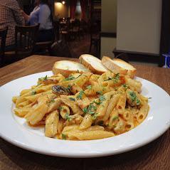 Pasta con el Sabor del Caribe · Irresistible penne pasta with shrimp and chicken in a slightly spicy jerk creamy sauce garnished with cilantro and parsley.