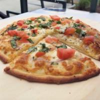 Pizza Margarita · Olive oil, hint of garlic, mozzarella cheese, ripe Roma tomatoes, Parmesan cheese, and fresh...