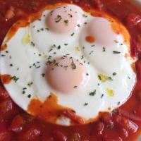 Huevos Rancheros · Three sunny side up eggs cooked in our delicious homemade spicy tomato sauce.