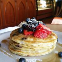 Blueberry Pancakes · 4 of our delicious homemade blueberry stuffed pancakes served with maple syrup and topped wi...