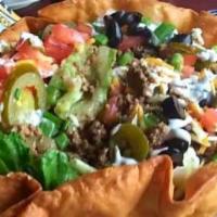 Taco Salad · Tortilla bowl filled with crisp lettuce, chopped tomato, black olives, jalapenos and shredde...