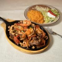 61. Combination Fajitas · Chicken, beef, and shrimp with tomatoes, onions and bell peppers.