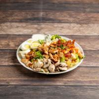 Classic Cobb Salad · Fresh greens topped with diced chicken, bacon, avocado, mushrooms, tomato and boiled egg. Se...