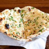 GARLIC NAAN · Garlic and herb-infused, teardrop-shaped leavened bread baked in a tandoor oven.