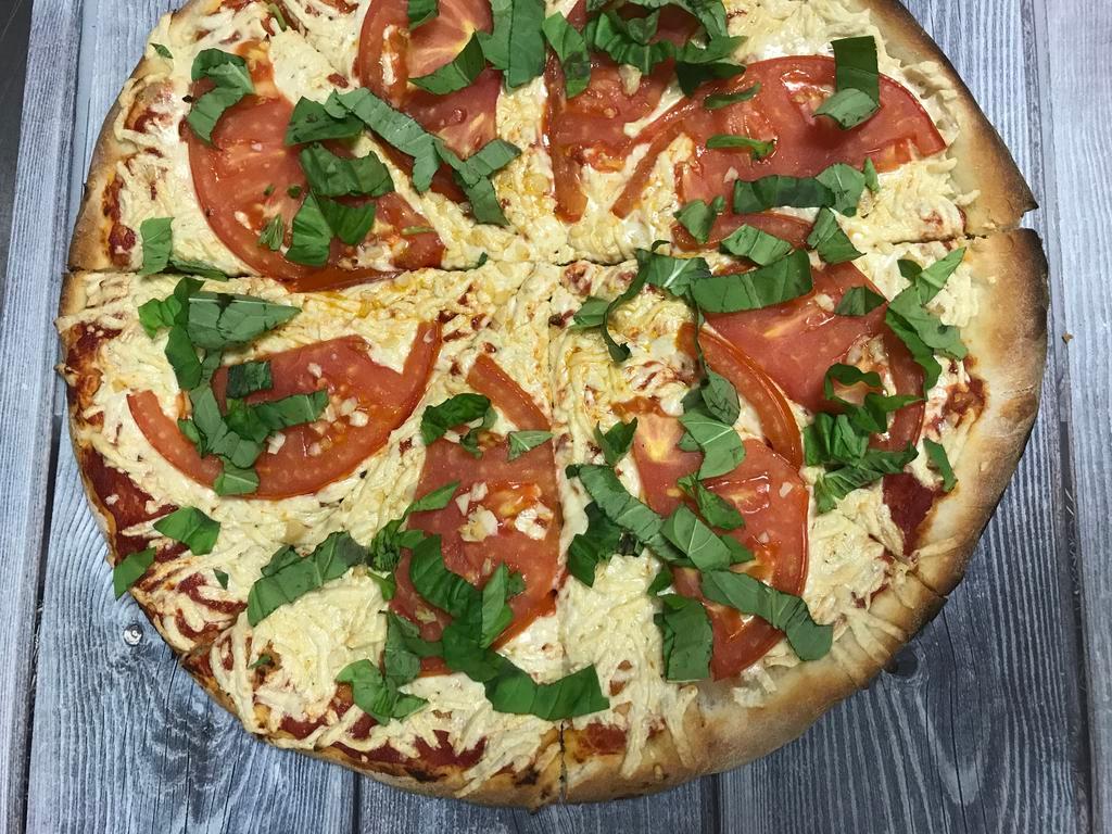 Vegan Margherita Pizza · Olive Oil, Pizza Sauce, Vegan Mozzarella, Vegan Parmesan cheese, Garlic, Sliced Tomatoes and Fresh basil on top.