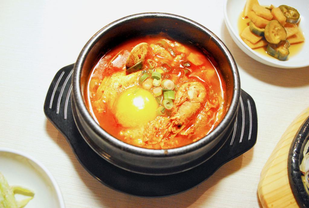 Soft Tofu Soup 순두부 · Spicy tofu soup made with freshly curdled soft tofu, mushrooms, onion, and red chili paste served in hot stone bowl topped with soft egg.