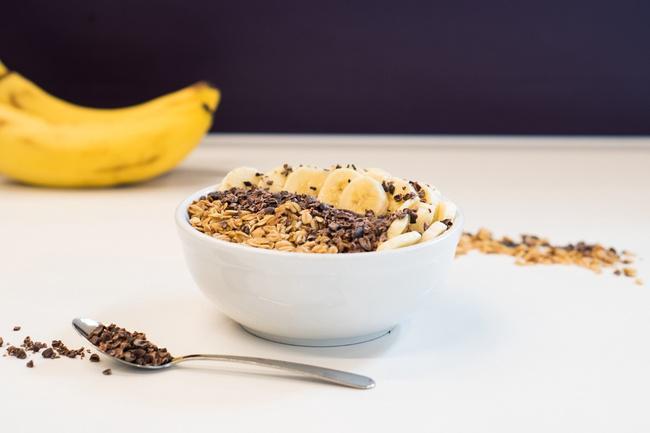 Cacao Bowl · Organic Acai blended with coconut milk and banana topped with fresh sliced banana, organic cacao nibs, gluten free granola, and local honey.