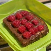 NUTELLA TOAST · Hearty slice of toasted whole grain bread spread with half Nutella and half Raspberry chia Jam
