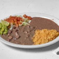 Carne Guisada · Served with rice, beans and guacamole salad.