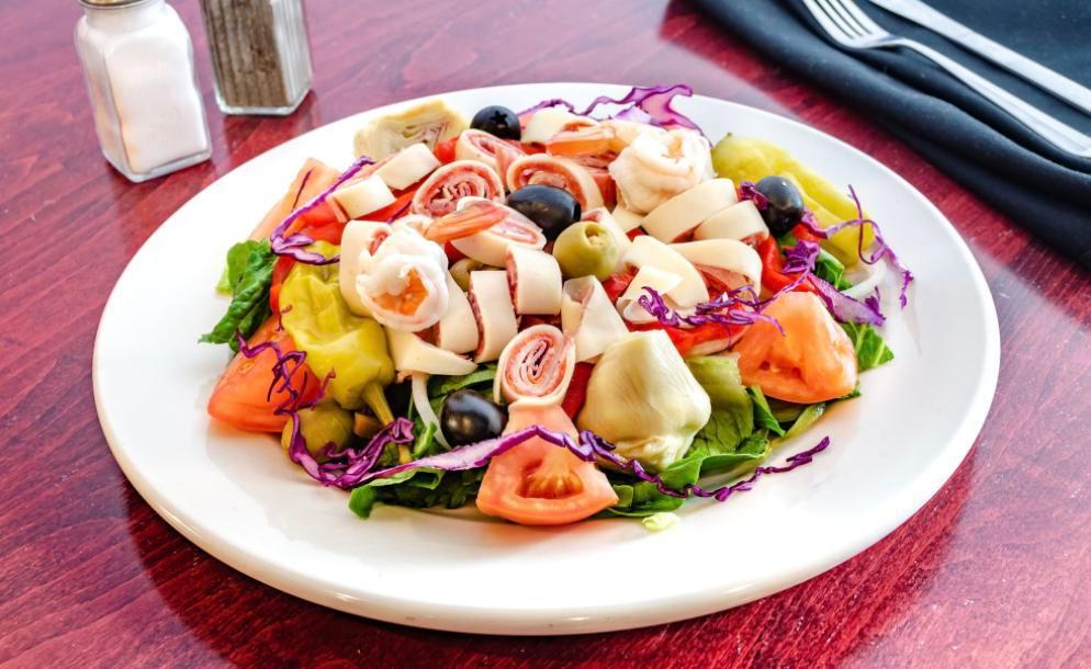 Antipasto Salad · Romaine lettuce, tomatoes, onions, green & black olives, pepperoncini, red sweet peppers, roasted red peppers, artichoke hearts, hot peppers, rolled-up pepperoni, salami, capicola, provolone & shrimps.