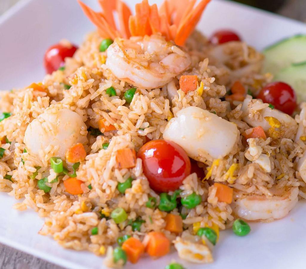 Fisherman Fried Rice · Fried rice with egg, shrimp, calamari, crab meat, peas & carrots, green onions, tomatoes, cilantro and cucumber.