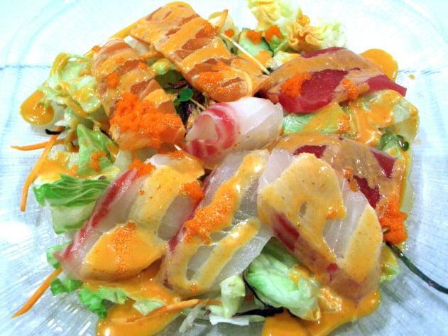 Sashimi Salad · Various cuts of sashimi on salad with Midori sauce.