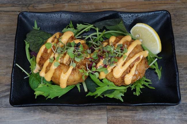 Crab Cakes · Two moist crab cakes drizzled with a spicy mayo sauce.