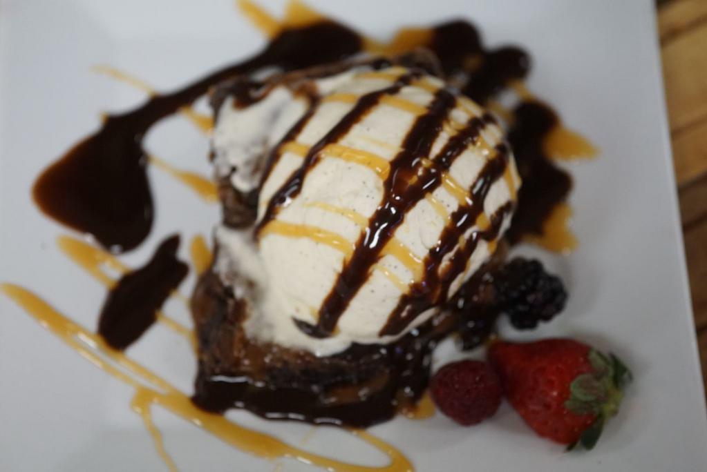 Brownie a Ia Mode · Freshly baked warm fudge brownie served with vanilla ice cream, caramel drizzle a hazel nut cookie and seasonal berries.