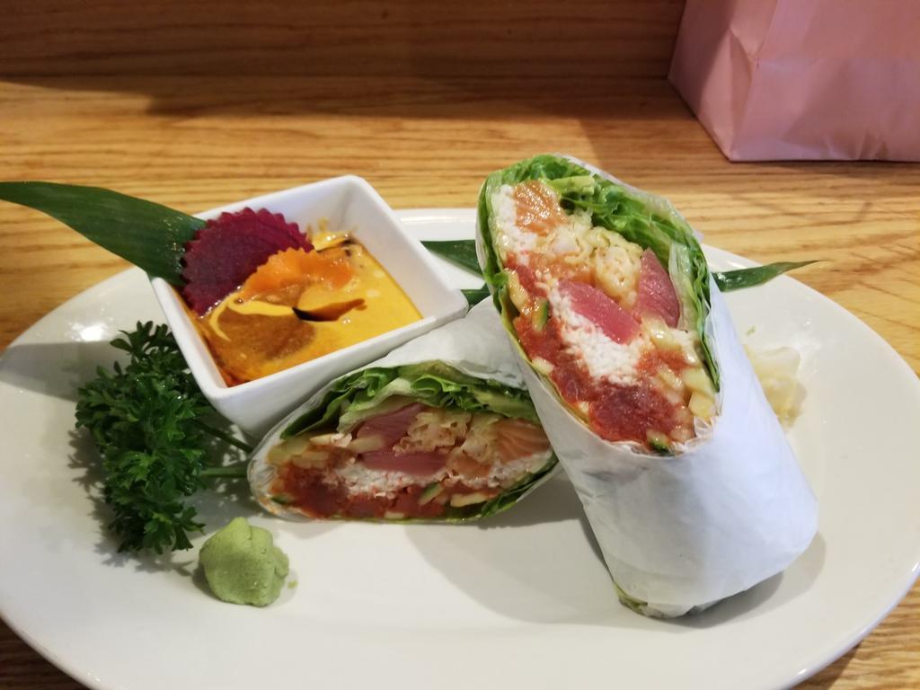 Sushi Burrito Roll · Shrimp tempura, crab, spicy tuna, seared tuna, salmon & avocado, wrapped in iceberg lettuce.