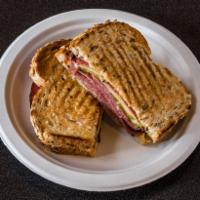 Pickled Pastrami Panini Sandwich · Sliced hot pastrami, topped with melted swiss cheese, sliced pickle and dijon mustard on whe...