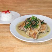 Pollo Lupita · Oven baked chicken leg with white mushrooms, spinaches in a creamy sauce. Side of white rice.
