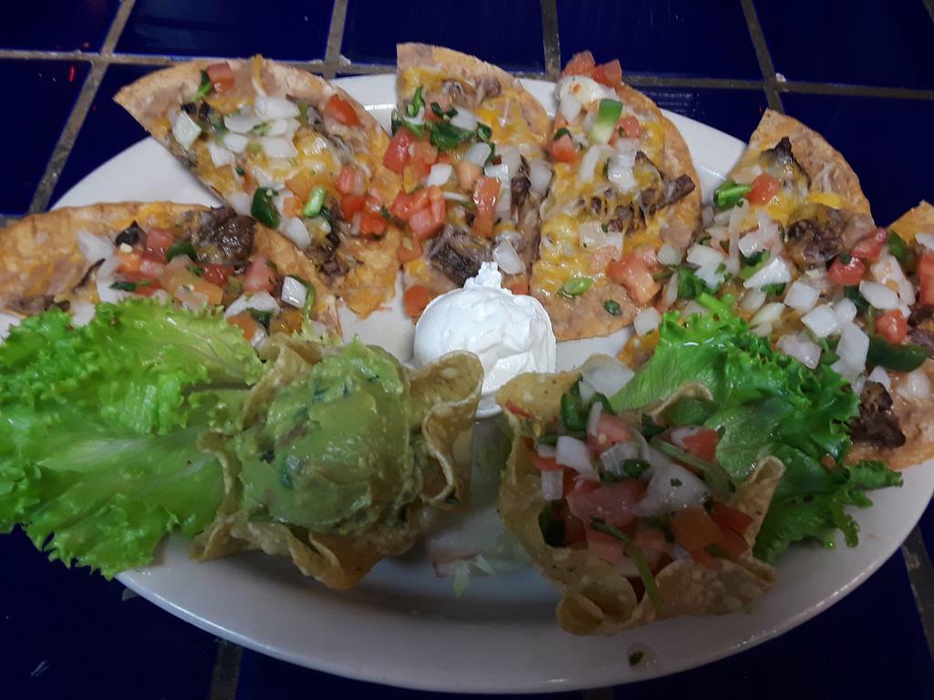 Fajita Nachos · Traditional nachos topped with either fajita steak or chicken, melted cheese and pico de gallo. Served with guacamole, sour cream and jalapenos.