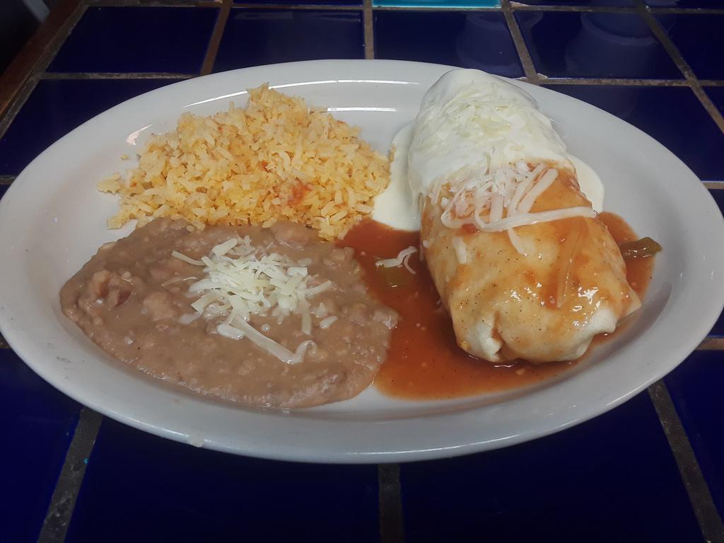 Baja Burrito · Bursting at the seams with Mexican rice, refried beans, cheese, lettuce, tomatoes, sour cream, salsa and your choice of seasoned ground beef or shredded chicken. Topped with ranchera sauce and queso. Add brisket or carnitas for an additional charge.