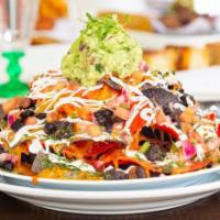 Chicken Nachos Grande Plate · Nachos piled high with cheese, jalapenos, refried beans, and pulled chicken.