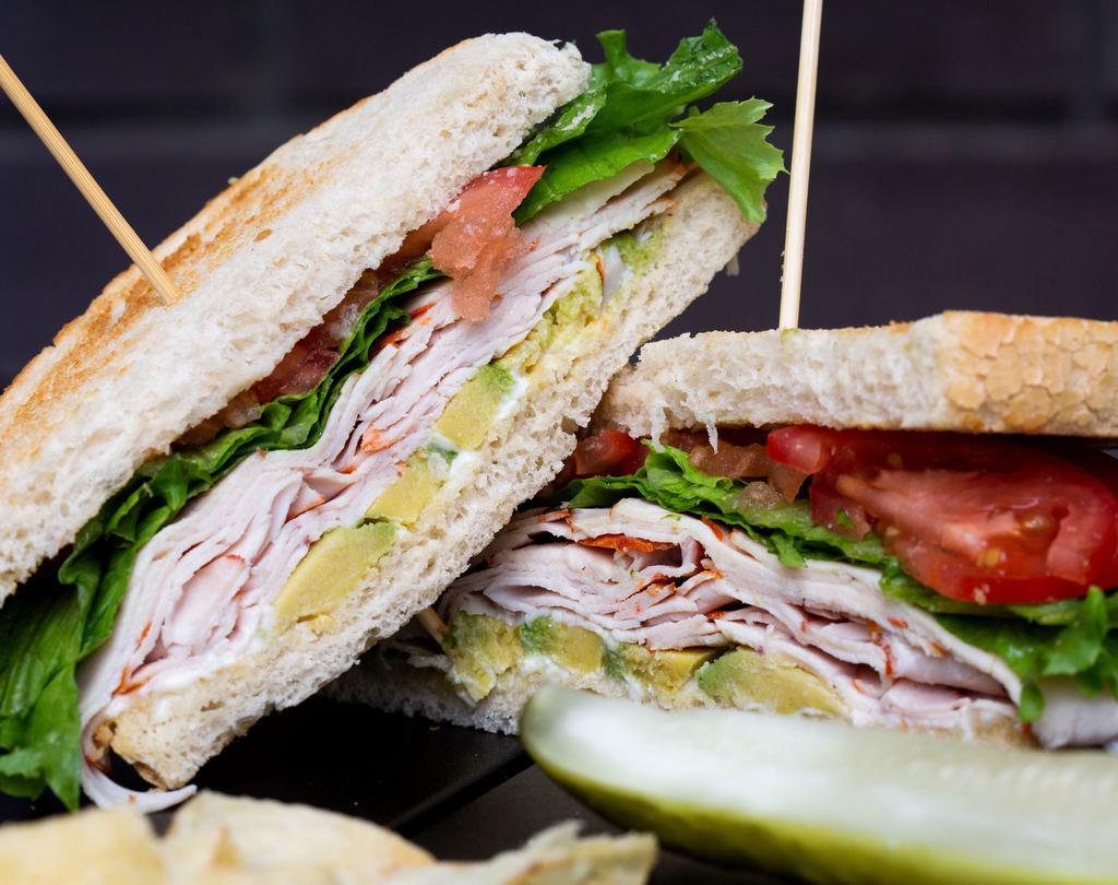 Turkey Avocado Sandwich  · Roasted turkey breast with Boar's Head provolone cheese, leaf lettuce, roasted tomatoes & avocado, finished with mayonnaise served on a baguette. Served with kettle cooked potato chips and a crisp pickle spear.