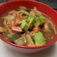 Vegan Tortilla Soup · Made With Vegetables and tortilla strings, avocado and tomate on top.
