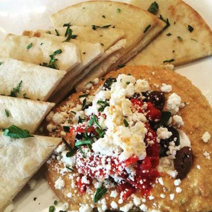 Hummus  · House-made with feta, sundried tomatoes, tzatziki and olives, served with warm pita bread or sliced veggies.