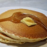 Buttermilk Pancakes · Three golden pancakes served with butter and syrup.