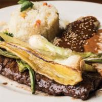 Carne Asada Tampiquena · Carne asada a la tampiquena. Choice skirt steak. Served with cheese enchilada topped with Me...