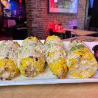 Street Corn · Grilled corn on the cob, drizzled with garlic aioli, dusted with Parmesan and fresh herbs.