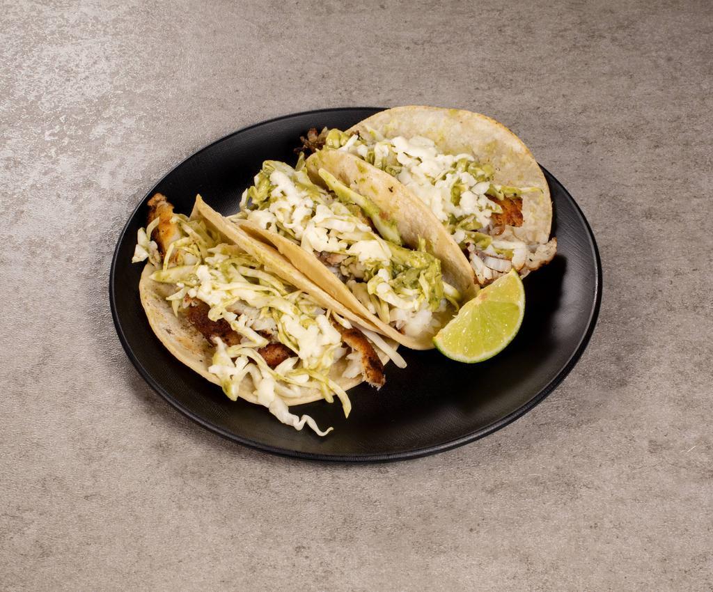 Fish Tacos · 3 grilled Tilapia corn tortilla tacos topped with avocado cream slaw, queso fresco and served with cilantro lime rice and a side of spicy arbol sauce. Gluten Free.