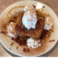 Cinnamon Caramel French Toast Breakfast · 3 slices of French toast served in a bowl with crumbled bacon topped with hot caramel and wh...