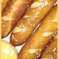 Pretzel Sticks · Warm pretzel sticks sprinkled with salt and served with cheddar cheese.