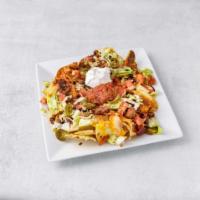 Macho Nacho Platter · A mountain of tortilla chips baked with homemade chili, green peppers and onions topped with...