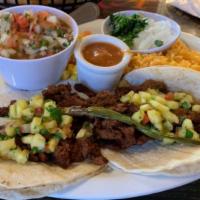 Tacos Al Pastor Speciality · 2 steak tacos with pastor seasoning topped with chunks of pineapple served with rice and bea...