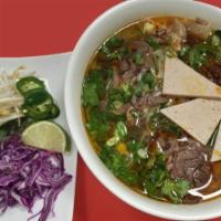 Spicy Noodle Soup - Bun Bo Hue · Thick vermicelli with spicy soup, beef shank, and Vietnamese pork meatloaf (cha lua).