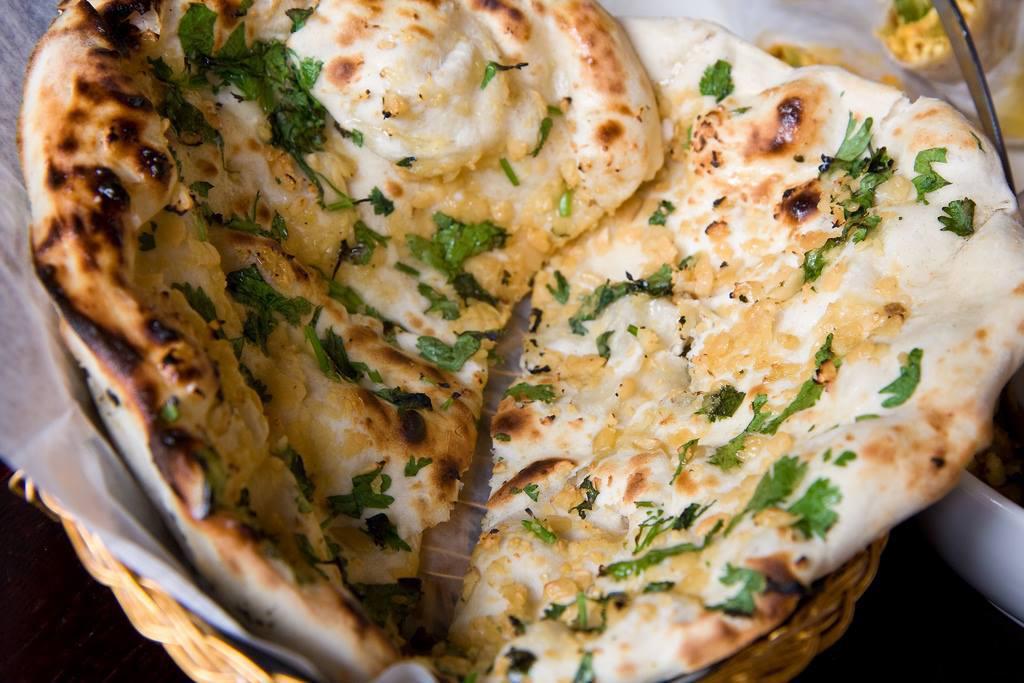 Garlic Naan · Freshly baked naan topped with chopped garlic and butter.