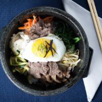 Bulgogi Dolsot Bi Bim Bap 불고기 곱돌 비빔밥 · Rice topped with vegetables, bulgogi, and egg.