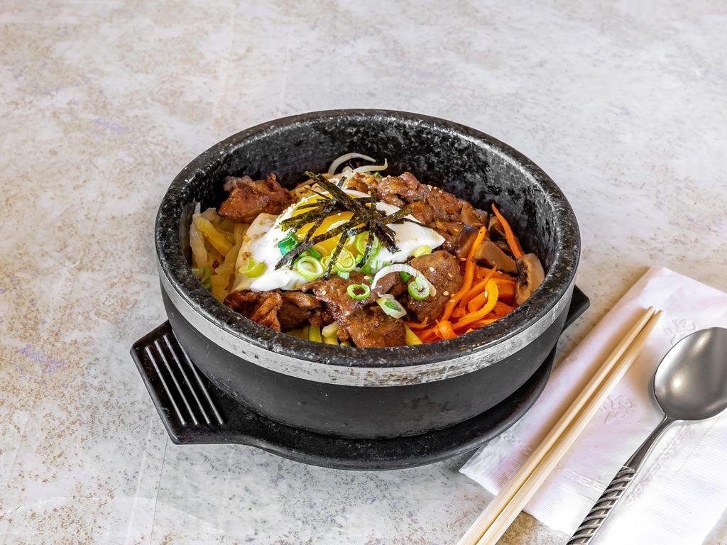 Marinated Pork Dolsot Bi Bim Bap 돼지갈비 곱돌 비빔밥 · Rice topped with vegetables, marinated pork, and egg.