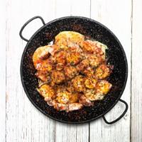 Pulpo a la Gallega · Chunks of octopus over sliced baked potatoes seasoned with paprika.