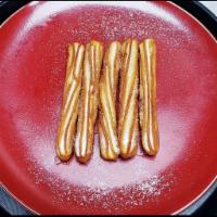 Churros con Chocolate · Crispy fried churros with chocolate cream and sugar.